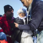 Voluntarios ayudan a una mujer anciana de Afganistán tras desembarcar con otros refugiados en Skala Sykaminias, en Lesbos, este miércoles.