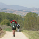 Un peregrino carga su mochila durante el Camino de Santiago