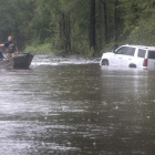 Efectivos de los cuerpos de rescate en una pequeña lancha por una calle inundada de Latta. C. HERRERA