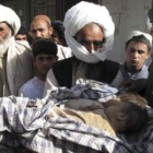 Familiares sujetan los cuerpos de dos niños fallecidos durante un bombardeo de la Otan.