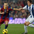 Iniesta controla el balón ante la oposición del centrocampista de la Real Sociedad Gorka Elustondo.