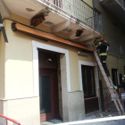 Dos bomberos retiran cascotes del balcón afectado en la calle del Reloj de Ponferrada. M. C.