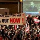 Manifestantes de la oposición libanesa siguen el discurso del presidente sirio por la televisión
