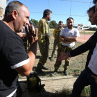 Luis Tudanca y Tino Rodríguez conversan con los brigadistas a uno y otro lado de la valla.