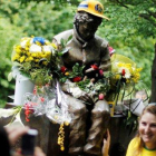 Una aficionada brasileña posa junto a la estatua que recuerda a Ayrton Senna en Imola.