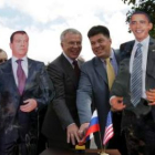 Ciudadanos rusos de fotografían con dos imágenes de Medédev y Obama.