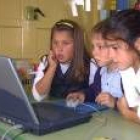 Unos niños emplean el odenador para navegar en Internet