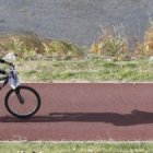 Una mujer hace ejercicio dando un paseo en bicicleta junto al río Bernesga.