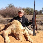 Un niño de siete años sostiene con la mano izquierda un rifle de casa y con la derecha acaricia el lomo del león que acaba de matar.
