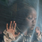 Una niña keniana de tres años juega tras una red antimosquito. STEPHEN MORRISON