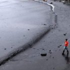 Una activista de Greenpeace trabaja en la limpieza del petróleo en el mar Amarillo.