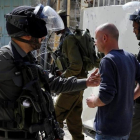 Soldados israelies arrestan a un joven palestino durante una protesta en la ciudad cisjordana de Hebron ayer lunes 17 de abril.