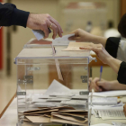 Una persona deposita su voto en la urna de una mesa electoral en los últimos comicios. JESÚS DIGES