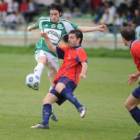 El delantero del Astorga Boni golpea el balón ante la oposición de un defensor de La Granja.