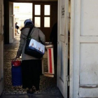 Una refugiada entra con sus pertenencias en el centro de Wilmersdorfer.