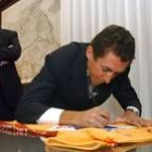 Roberto Heras firma su jersey oro en presencia del presidente de la Junta, Juan Vicente Herrera