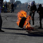 Manifestantes palestinos queman un neumático en protesta por la decisión de EEUU, en Ramalá, este martes 26 de diciembre