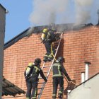 Los bomberos trabajan en la extinción de fuego originado en una casa de la calle Nueva York.