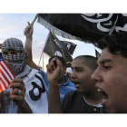 Manifestantes libios queman una bandera de EEUU en protesta por la detención de Al-Libi, en Benghazi.