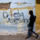 Un joven pasa ante un cartel que acusa a Ortega de asesino. JORGE TORRES