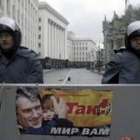 Dos policíaas vigilan una calle vacía de Kiev parapetados tras una valla con un póster de Yúschenko