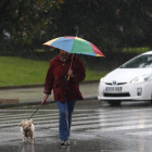 Una mujer se resguarda de la lluvia bajo su paraguas