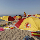 Sombrillas con los colores de la bandera de España en la playa de Arenys de Mar para contrarrestar las cruces y lazos. ANDREU DALMAU