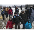 Familias de refugiados, muchos procedentes de Oriente Próximo, llegan a pie a Serbia, para continuar su viaje hacia Europa occidental, este lunes.