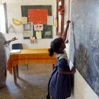 Una niña saharaui junto a la profesora haciendo unos problemas en la pizarra de la clase