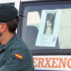 Un efectivo de la Guardia Civil junto al cartel de la joven. XOÁN REY