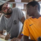Un voluntario habla con un niño que ha sido rescatado, a bordo del barco de Proactiva Open Arms.