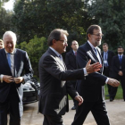 Artur Mas recibe a Mariano Rajoy. Tras ellos, el ministro García-Margallo y Jorge Moragas, hoy en el palacio de Pedralbes.