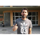 El extremo leonés, ayer tras el entrenamiento, hace un gesto de optimismo ante las puertas del Palacio de Deportes. DL