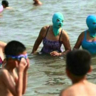 Bañistas en una playa de China luciendo un 'Facekini'