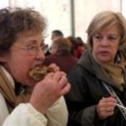 Dos mujeres disfrutan de la cecina en la última feria de Vegacervera