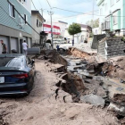 Un vehiculo permanece atrapado entre el lodo en una calle destruida tras el fuerte terremoto.