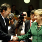 Mariano Rajoy saluda a Angela Merkel en un momento de la sesión europea de ayer.