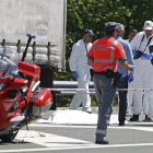 Los investigadores, junto al cadáver, que permanece tapado en el lugar de los hechos.