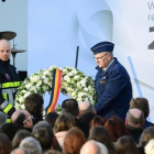 Un bombero y un agente de seguridad colocan un corona de flores en el aeropuerto de Zaventem, durante el homenaje a las víctimas de los ataques yihadistas, en Bruselas, el 22 de marzo.