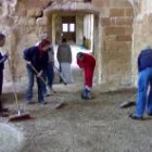 Los voluntarios limpian la parte del antiguo comedor de los monjes del monasterio de Sandoval