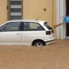 Un hombre achica agua de su casa en Gerona, inundada tras las fuertes lluvias