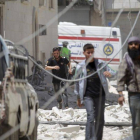 Un grupo de civiles junto al lugar donde ha estallado un barril lanzado por el régimen sirio.