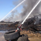 Las mangueras del último retén de bomberos arrojan agua sobre el material quemado