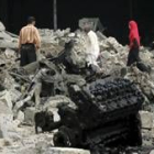 Unos iraquíes pasan por delante del coche bomba que explotó ayer en Bagdad