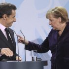 Merkel y Sarkozy conversan al final de la rueda de prensa tras su reunión en Berlín.