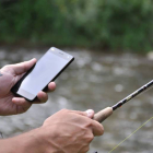 Un pescador con la aplicación MyFishingMaps instalada en su teléfono móvil.