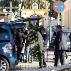 Servicios funerarios portan coronas de flores en el tanatorio de la barriada malagueña de El Palo.