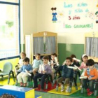 Una de las educadoras y los niños en el acto de graduación en el centro infantil de Cistierna.