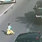 Un niño chino se mete con su coche de juguete en una autopista en hora punta.