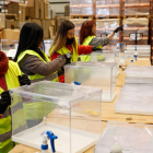 Varios operarios trabajan en las urnas en el centro logístico para las elecciones locales y autonómicas del 28-M, en Alcalá de Henares. CHEMA MOYA